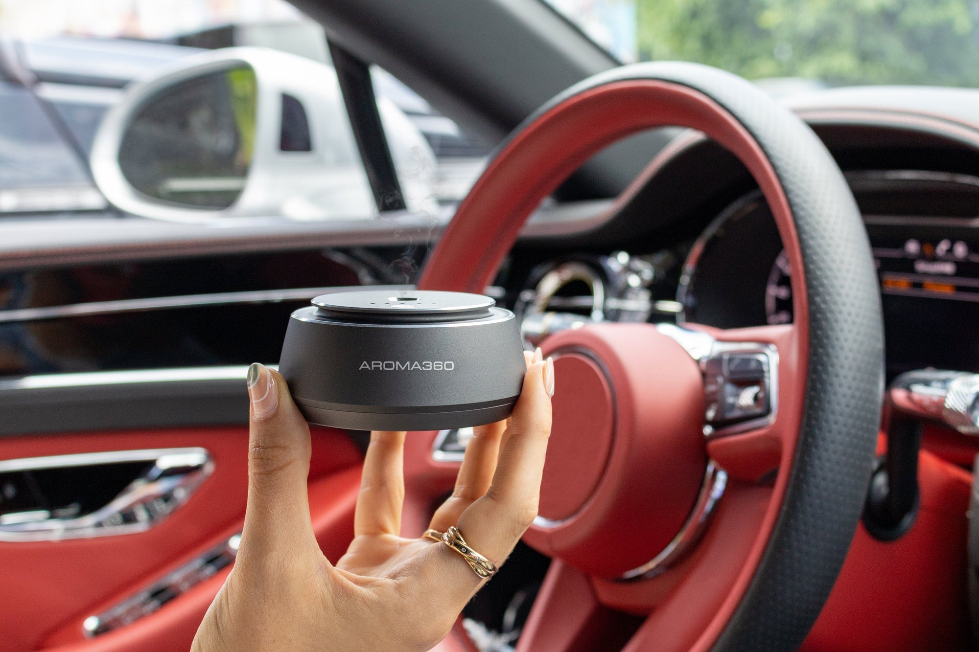 woman holding car diffuser in a car with red interior